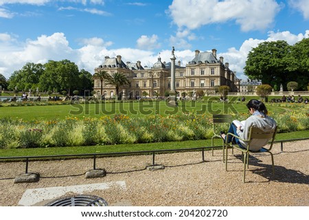 PARIS - MAY 13 : Luxembourg Garden in Paris , France on May 13, 2014 A Parisian reading a book in Luxembourg Garden (Jardin du Luxembourg)