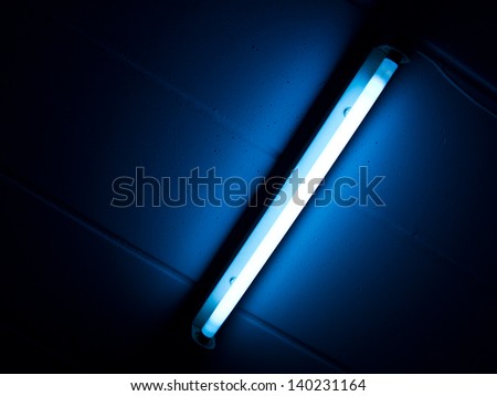 Detail of a fluorescent tube mounted on a wall, false green color light