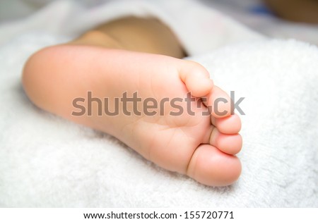 A close up of tiny baby feet on the white cloth