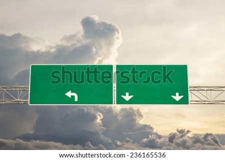 Empty green road sign against sky with clouds - a place for your own text on a green sign.