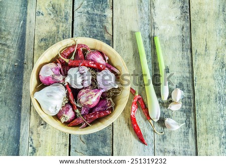 Garlic,onions,dry pepper and lemon grass in wooden bowl on wooden table