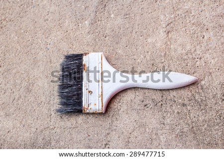 Old paint brush on the cement floor