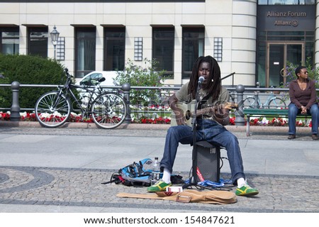 BERLIN, GERMANY - SEPTEMBER 5: man plays music and sings songs on street on September 5, 2013.