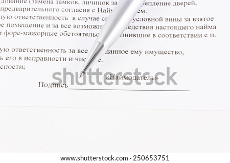 Signature of the contract with pen on paper with text.