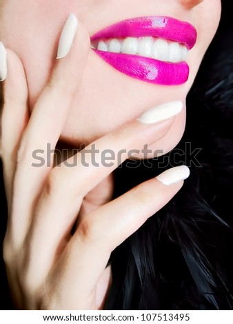 Closeup of a happy smiling woman's face pink lips teeth and hand