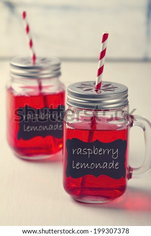 Two raspberry lemonade mason jars with stripe straws