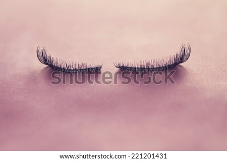 Close up of false eyelashes on pink paper background