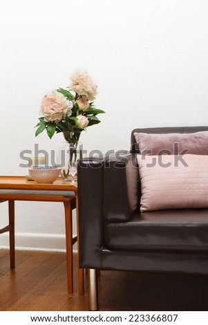 Vintage sofa interior detail with side table and flowers