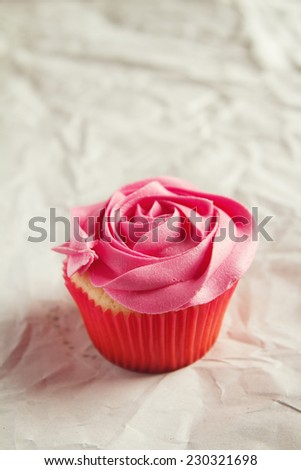Vanilla cupcake with pink rose piping icing and clear space for text