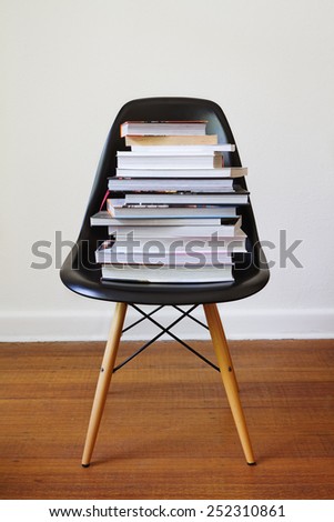 Contemporary black dining chair with stacked high with books