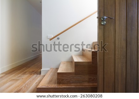 Modern staircase of oak wood beside front door in contemporary home horizontal