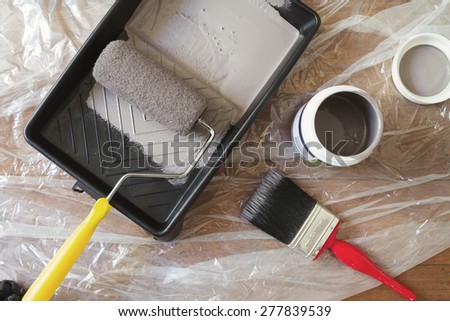 Overhead view of home painting equipment brush, roller, tray and paint pot