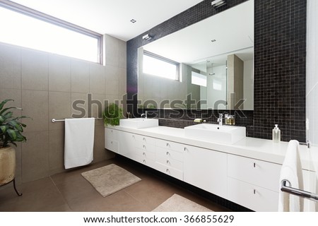 Black mosaic tiled splashback and double basin bathroom ensuite