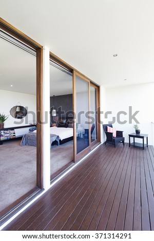 Master bedroom and large glass sliding doors to balcony in luxury Australian home