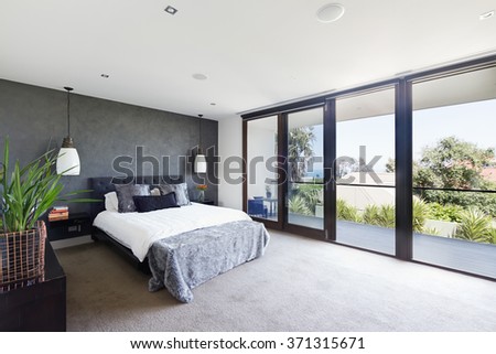 Spacious interior of designer master bedroom in luxury contemporary Australian home