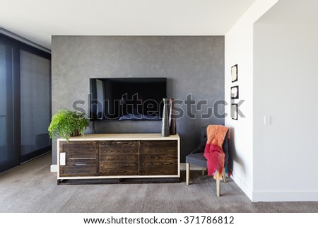 Wall mounted tv and buffet in spacious master bedroom with decor items