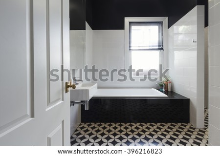 Designer bathroom renovation with black and white floor tiles horizontal