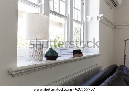 Close up details of lamp books and ornament objects on window sill