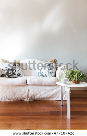 Blank painted grey wall with white country style sofa and coffee table