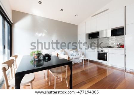 Open plan small apartment with kitchenette, dining table and sofa