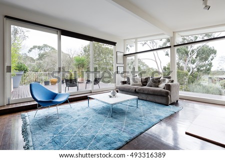 Glassed wall Australian living room with amazing views of bush treetops