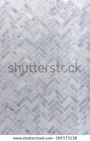 Background of grey and white marble tile in herringbone pattern
