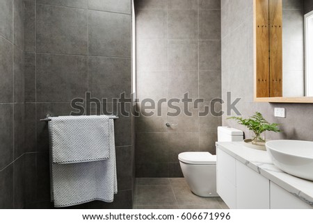 Charcoal grey modern bathroom with marble benchtop and wood mirror