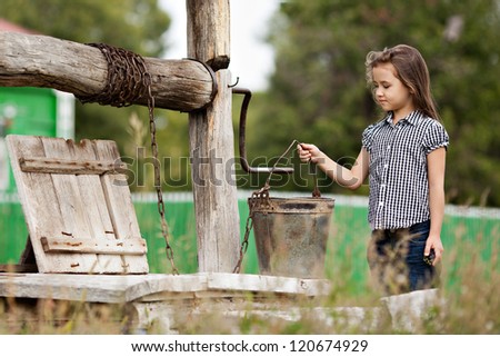 Girl gets water from a well in the village