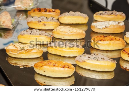 Small sandwiches as an appetizer at a party. The sandwiches are stuffed with creamed tuna, salmon and peppers