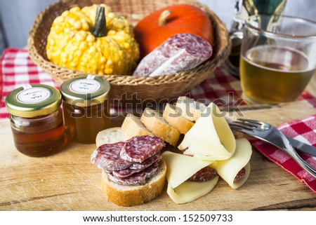 Wooden cutting board with salami, cheese, honey. Typical Italian food
