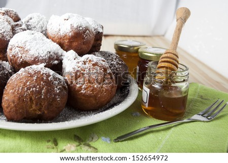 Ball shaped pancakes with powdered sugar and honey in jars