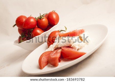 Italian Buffalo mozzarella cheese and red tomatoes on a white background
