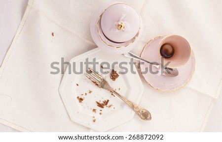 Cup of coffee and plate empty after breakfast in elegant porcelain service.