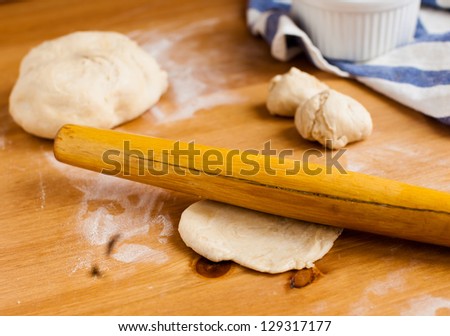 Dough on wooden board with the rolling pin