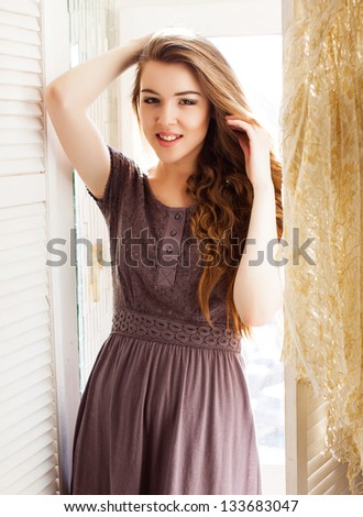Woman near the windows, smiling at camera