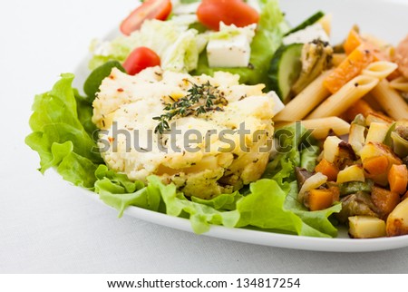 Potatoes, pasta, salad, bread on white plate