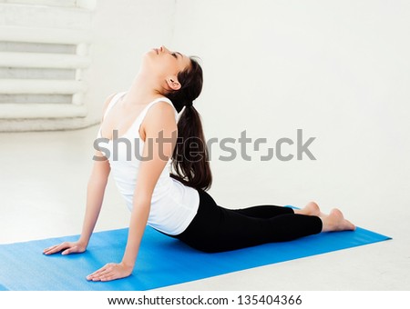 Girl in black workout clothes doing pilates. Small amount of fringing.