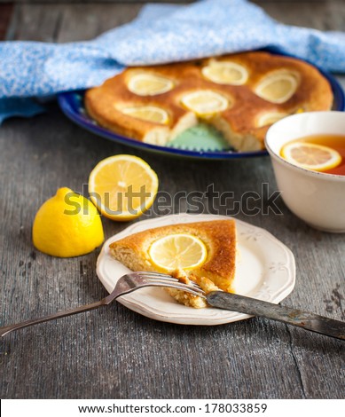Slice of lemon pie with fresh lemons