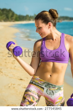 Beautiful fit female fitness model training and working out outside in summer at part of healthy lifestyle.