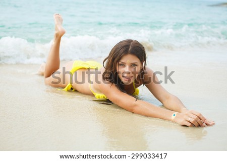Relaxing beach woman enjoying the sea in swimsuit. Glamorous girl with gold tattoo on the hand.