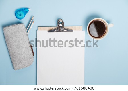 Creative desktop with laptop, coffee and stationery on blue table. Top view, Flat lay