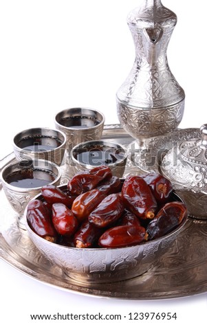 Antique silver pitcher and coffee cup set with dates in a tray isolated on a white background vertical Including clipping path Antique silver pitcher and coffee cup set with dates in a tray isolated on a white background vertical Including clipping path