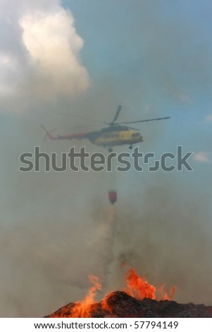 Fire rescue helicopter draining water over fire