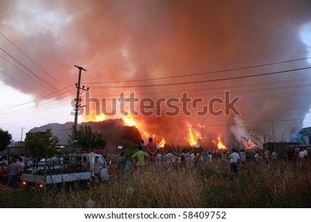 KOCAELI - TURKEY - JULY 17: Turkey\'s biggest chipboard factory on fire and people watching it curiously July 17, 2010 Gebze - Kocaeli, TURKEY