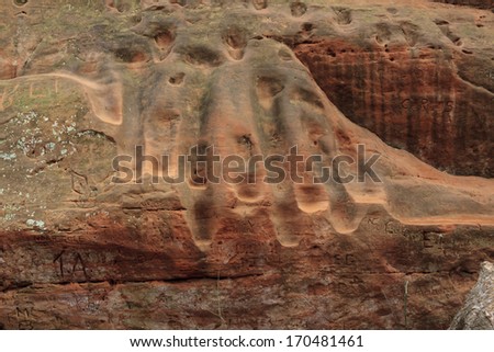 Footsteps and graffiti worn into soft sandstone canyon walls in Oklahoma\'s Red Rock Canyon State Park
