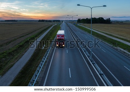 Red truck on the road at sunset