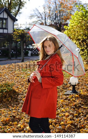 Young beautiful woman in the park in a fashion shot,  holding umbrella and smiling - caucasian woman, autumn, fall, park
