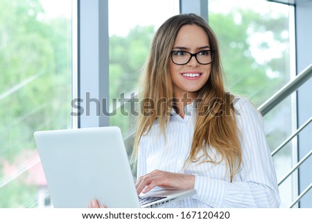 Portrait of a smiling successful businesswoman with computer
