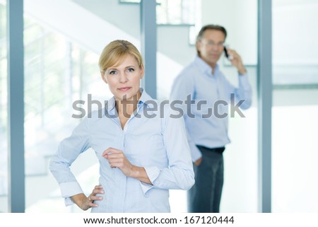 Portrait of confident business partners looking at camera with female leader in front