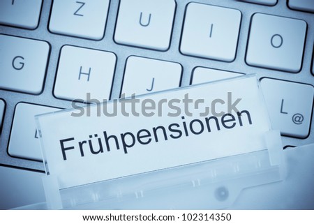 a folder for files in hanging folders in front of a computer keyboard on the theme: early retirement